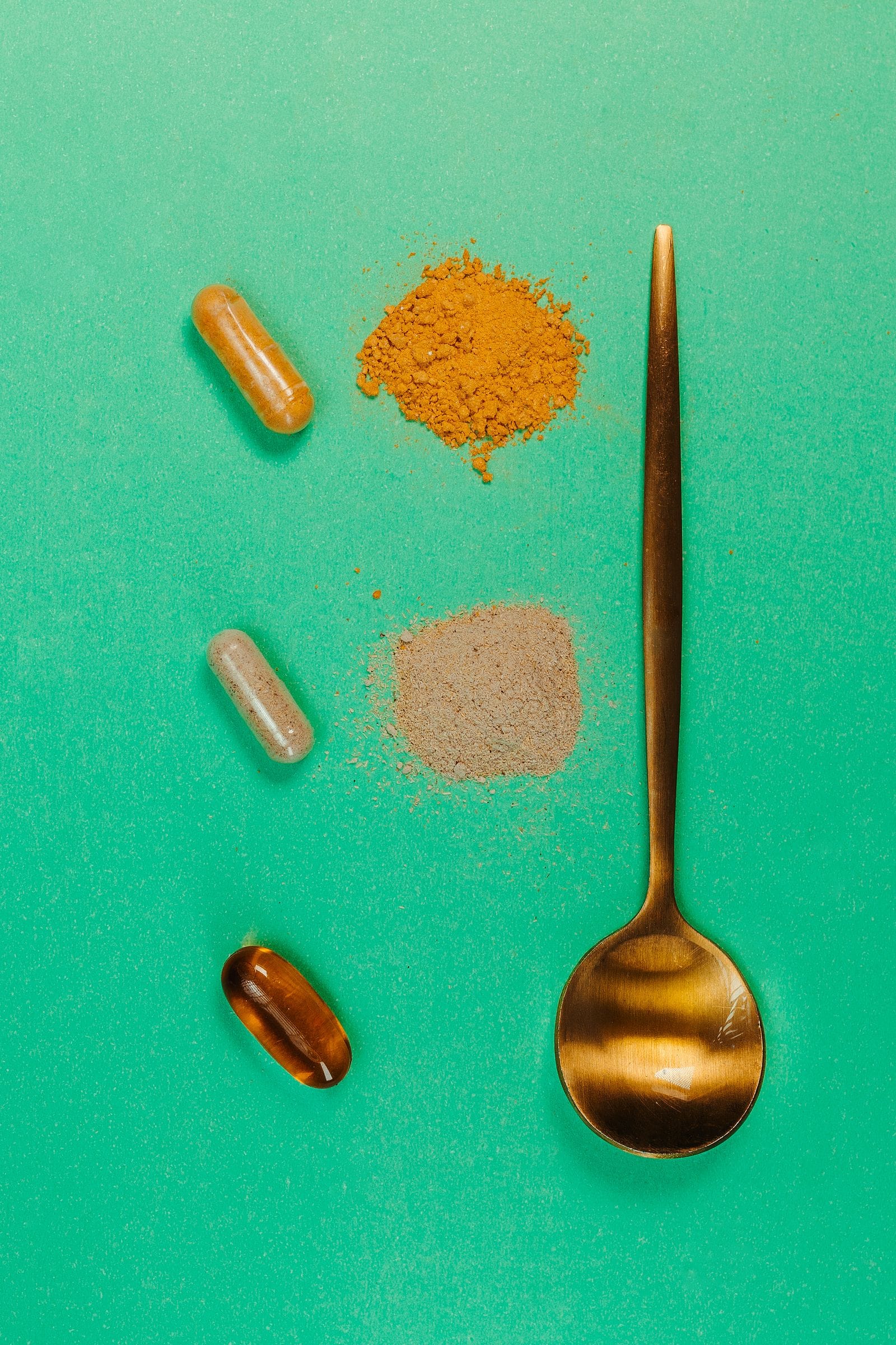 Ashwagandha capsules and powder on a green surface