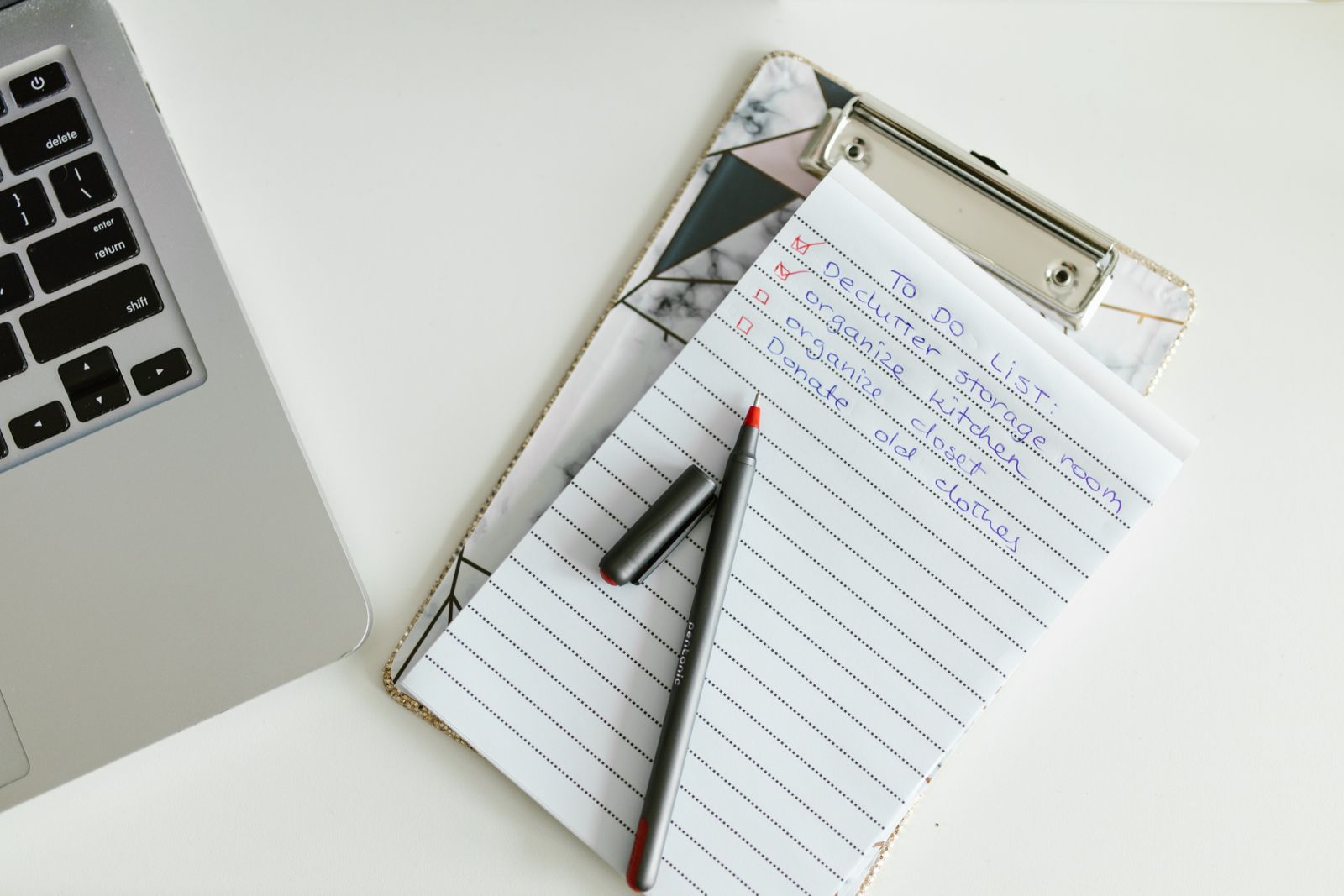 Checklist on a clipboard beside a laptop and pen, representing a checklist for choosing an Ayurveda centre