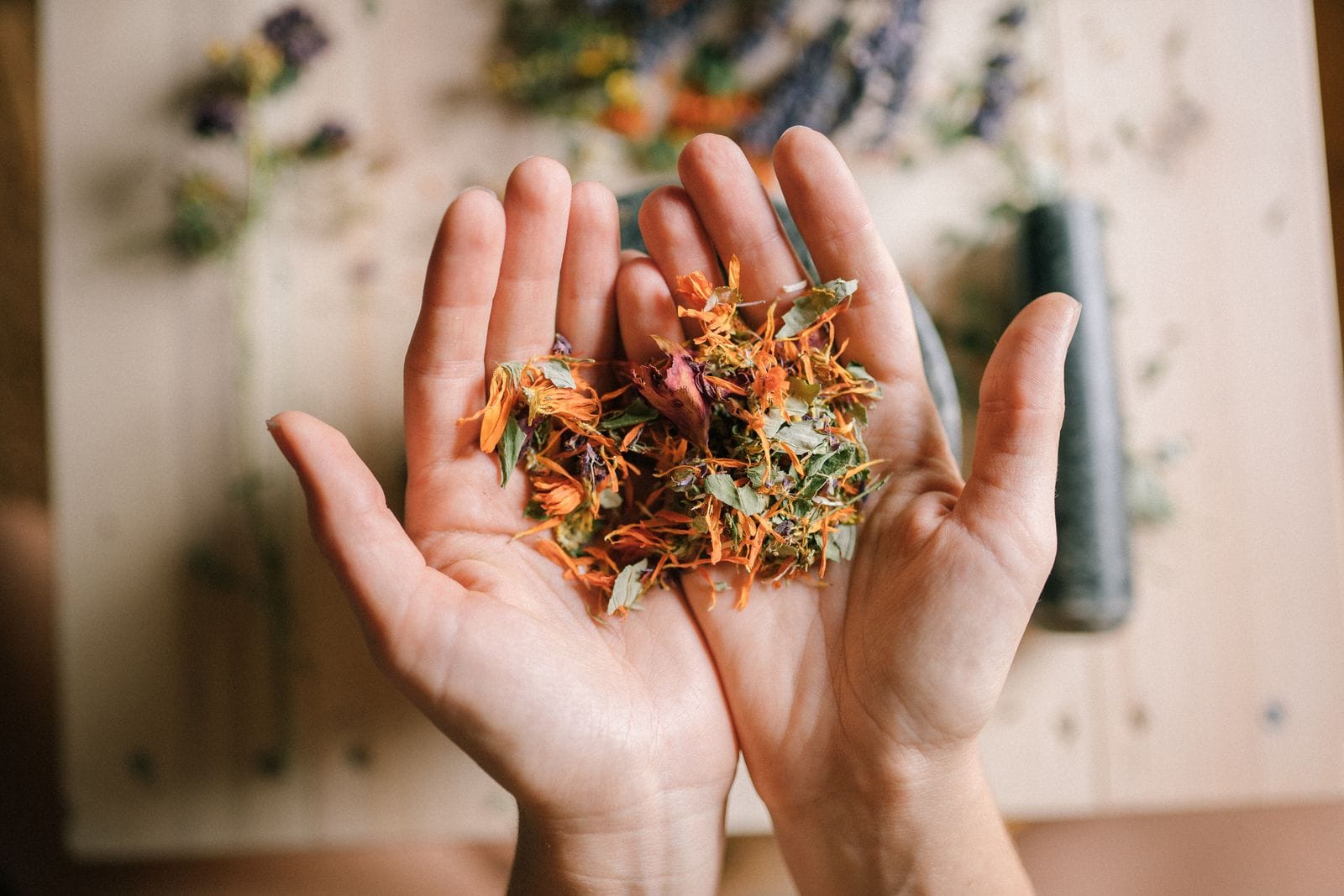 Mix of dried herbs on a wooden surface, like the fruits and powders used in Ayurvedic formulations