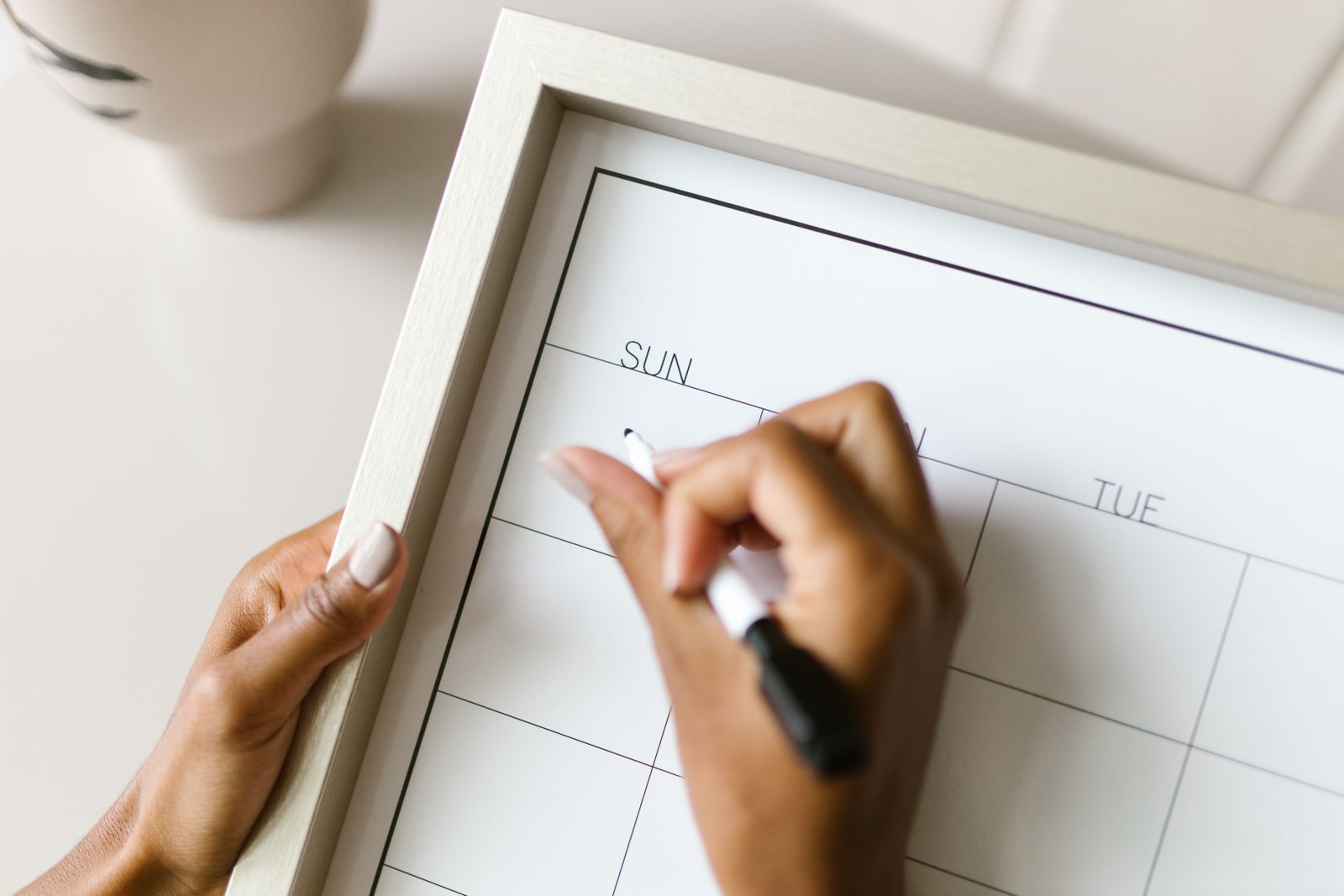 Hands marking dates on a wall calendar while planning a Panchakarma program