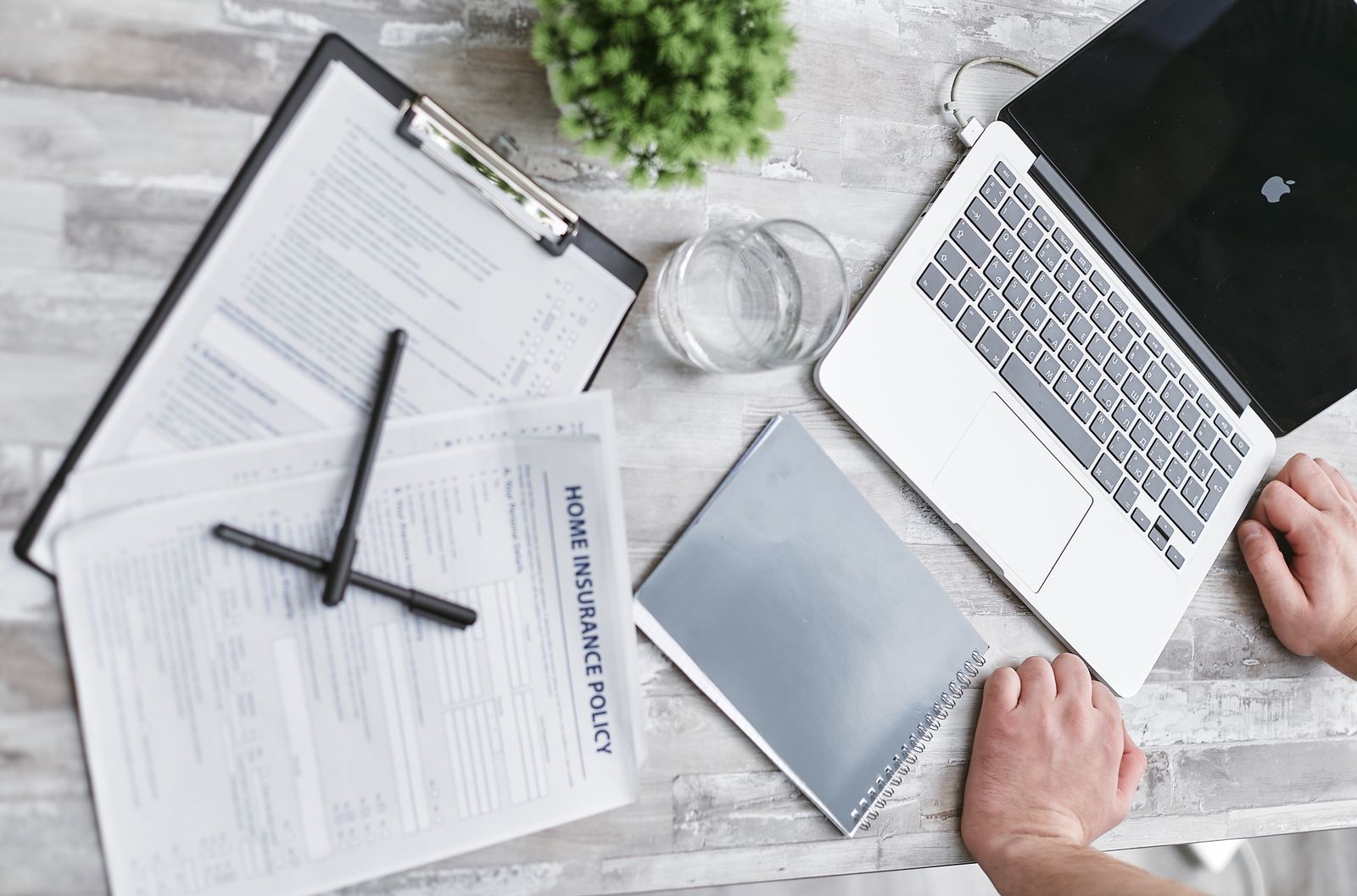 Insurance forms and documents on a desk, representing travel insurance for Ayurvedic treatment abroad