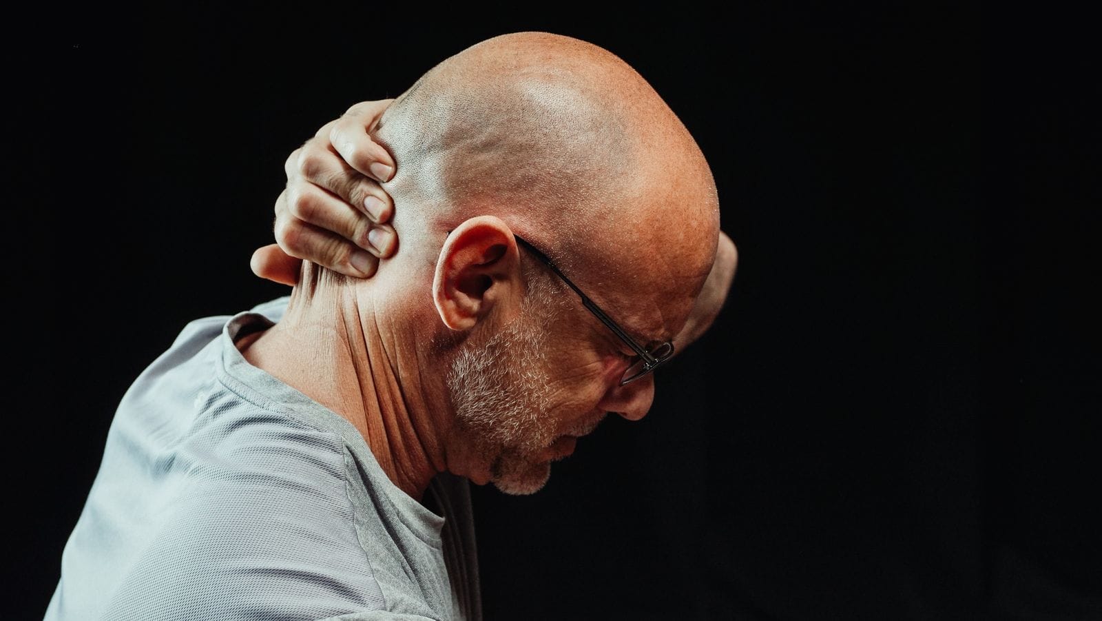 Man holding his neck in discomfort, representing cervical spondylosis and neck pain