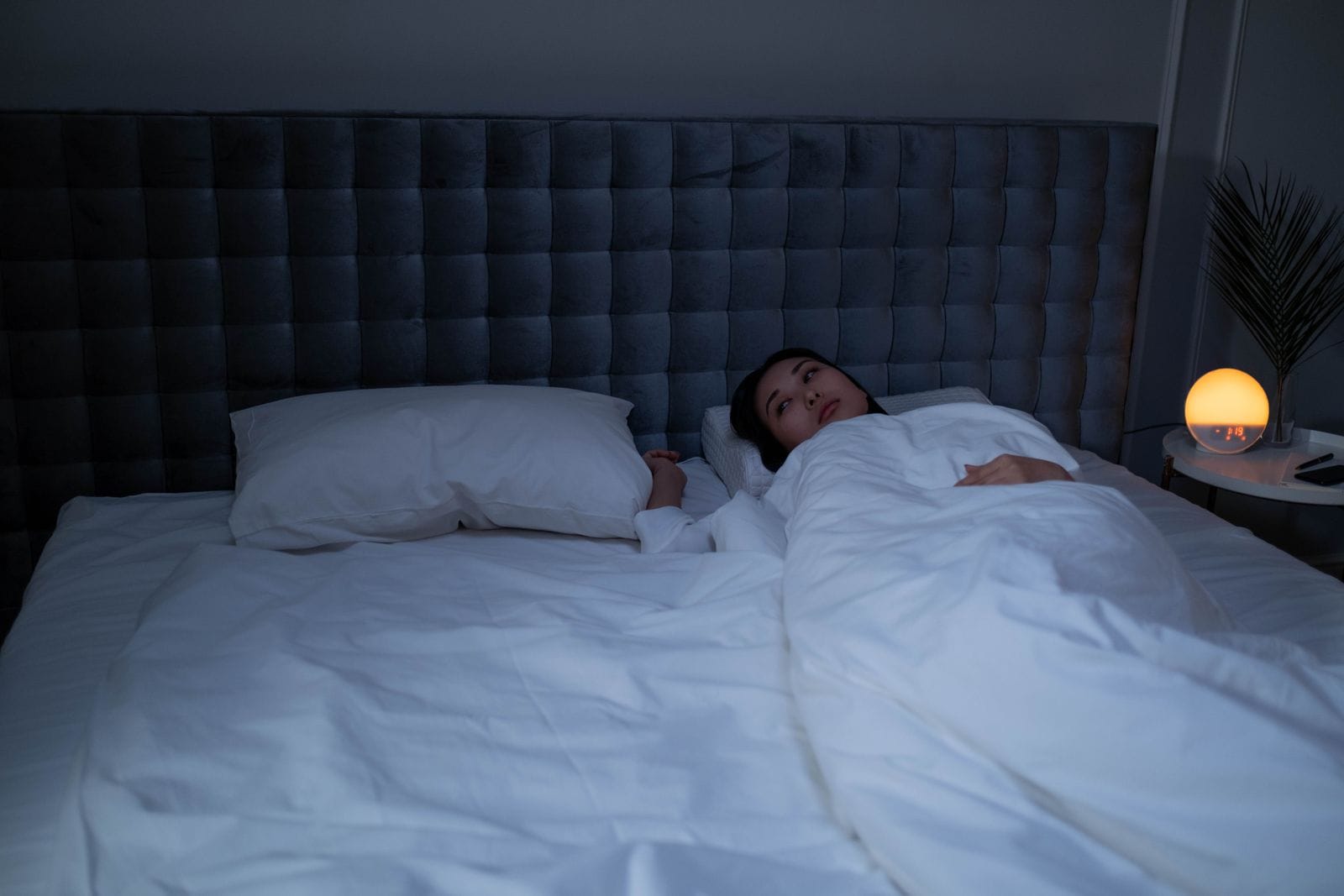 Woman lying awake in bed at night with insomnia