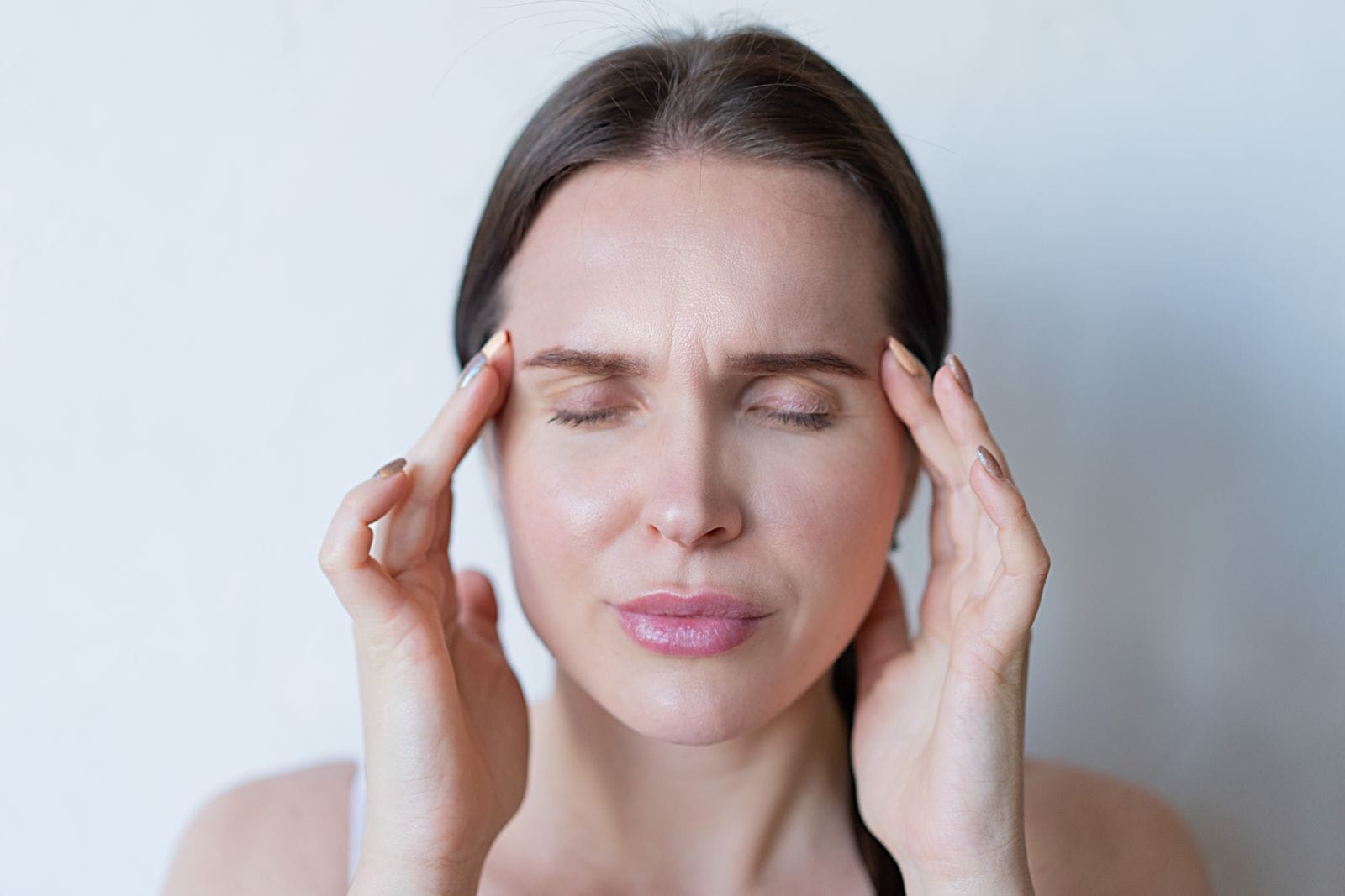 Woman holding her temples with a headache